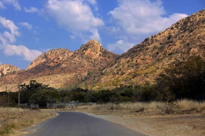 Rocky hills near Rustenburg and a quiet tar road (stock photo)