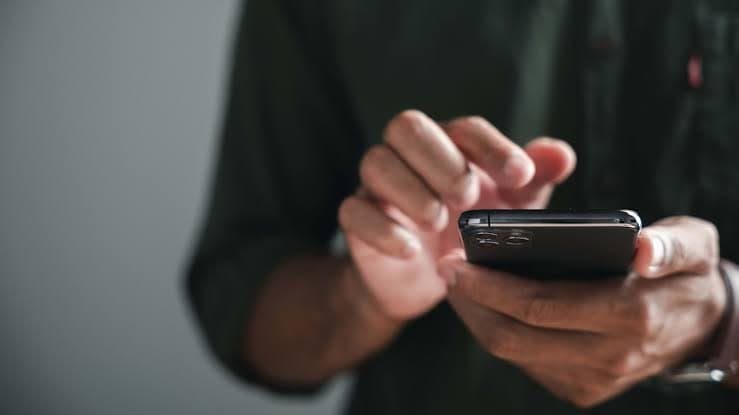A person tapping on their phone (stock photo)