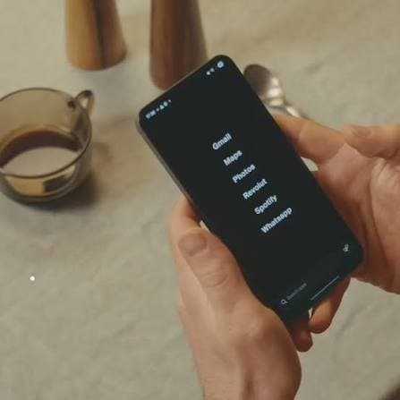 Hands holding a phone with a list of apps (stock photo)